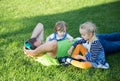 Young father with two daughters lying on grass in a park Royalty Free Stock Photo