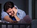 Young father under stress due to baby crying at night Royalty Free Stock Photo