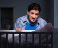 Young father under stress due to baby crying at night Royalty Free Stock Photo