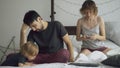 Young father upset because his daughter and wife bother him to work at home