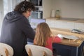 Father working from home with little daughter during covid-19 lockdown. Back view, copy space