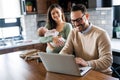 Young father works on laptop while his wife looks after child.Work from home parenting telecommuting Royalty Free Stock Photo