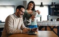 Young father works on laptop while his wife looks after child.Work from home parenting telecommuting Royalty Free Stock Photo