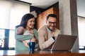 Young father works on laptop while his wife looks after child.Work from home parenting telecommuting Royalty Free Stock Photo