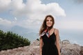 A young fearless woman poses after crossing a rope bridge over a precipice high in the mountains.