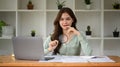 Young female accountant reading online information on laptop screen with magnifying glass Royalty Free Stock Photo