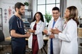 African doctor holding x-ray scan, standing in hospital room with group of physicians in front Royalty Free Stock Photo