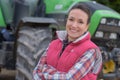 Young female agricultor on field tractor in background