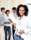 Young female architect holding blueprints. Beautiful business woman holding blueprints with colleagues discussing in Royalty Free Stock Photo