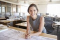 Young female architect leaning on desk smiling to camera Royalty Free Stock Photo