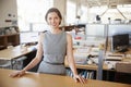 Young female architect in open plan office smiling to camera Royalty Free Stock Photo