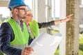 Young female architect pointing at something to her colleague at a construction site Royalty Free Stock Photo
