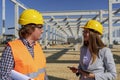 Young Female Architect Using Digital Tablet And Having Conversation With Construction Foreman At Construction Site Royalty Free Stock Photo