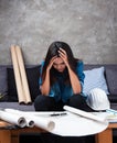 The young female architect withe blue shirt is working on project,put her hands touch head,serious emotion ,hard work Royalty Free Stock Photo