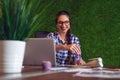 Young female architect working in her office, making some adjustments to her blueprint