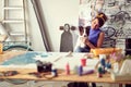 A young female artist is enjoying a break with her dog while working on a new painting in the studio. Art, painting, friendship, Royalty Free Stock Photo