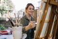 Young female artist enjoying painting in backyard Royalty Free Stock Photo