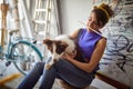 A young female artist having a good time in her studio while playing with her dog. Art, painting, friendship, studio Royalty Free Stock Photo