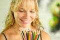 Young female artist holding colored pencils and smiling Royalty Free Stock Photo