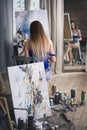 Young female artist painting abstract picture in studio, beautiful woman portrait Royalty Free Stock Photo