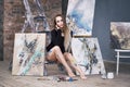 Young female artist painting abstract picture in studio, beautiful woman portrait Royalty Free Stock Photo