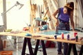 A young female artist is using a spatula to spread the paint over a new painting she is working on in the studio. Art, painting, Royalty Free Stock Photo