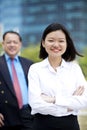 Young female Asian executive and senior Asian businessman smiling portrait Royalty Free Stock Photo