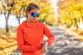 A young female athlete checks her running performance on a smart watch, listens to music through headphones and wears sports Royalty Free Stock Photo