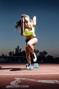 Young female athlete launching off the start line in a race. Royalty Free Stock Photo