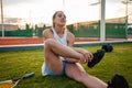 A young female athlete was injured. Tennis court, sunset. The girl suffers from pain, stretching, ligament damage Royalty Free Stock Photo