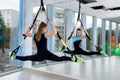 Young female athletic doing exercises training legs with trx straps in fitness gym Royalty Free Stock Photo