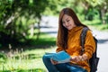 A female backpacker looking for direction on the map while traveling on a mountains road Royalty Free Stock Photo