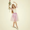 Young Female Ballet Dancer. Full length portrait of a little ballerina in a mask with rose flower Royalty Free Stock Photo