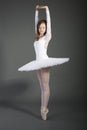 Young female ballet dancer posing over grey background Royalty Free Stock Photo