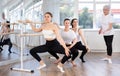 Young female ballet dancer practicing grand plie at barre