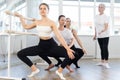 Young female ballet dancer practicing grand plie at barre