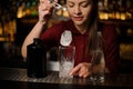 Young female barman putting an ice cube into a glass Royalty Free Stock Photo