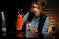 Young female bartender attentively pours carbonated drink to glass using siphons. Royalty Free Stock Photo