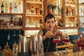 Young female bartender standing behind a bar counter making cocktails Royalty Free Stock Photo