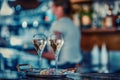 Young female bartender wearing face mask pouring sparkling white