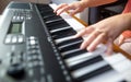 Young female beginner teaches itself playing on the electric piano, instrument playing, teachning Royalty Free Stock Photo