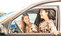 Young female best friends having fun at car roadtrip moment - Transportation concept and urban ordinary life