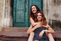 Young female best friends sitting on stairs and hugging. Happy girls laughing and having fun Royalty Free Stock Photo