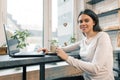 Young female blogger in coffee shop with laptop computer