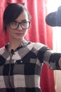 A young female blogger shoots himself on camera, pretty brunette in glasses, lifestyle vlog