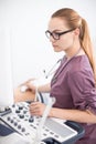 Young female blonde doctor using ultrasound scanner. Echography machine