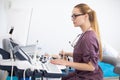 Young female blonde doctor using ultrasound scanner. Echography machine