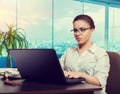 Female bookkeeper in glasses using laptop