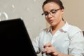 Female bookkeeper in glasses using laptop