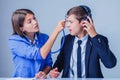 Young female boss hold stethoscope and exam the head of her employee as if she want to say: are you crazy Royalty Free Stock Photo